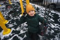 Happy child kid boy swinging on a swing at playground in the park in autumn Royalty Free Stock Photo