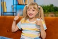 Happy child kid girl looking approvingly at camera showing thumbs up, like positive sign, good news Royalty Free Stock Photo