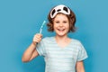 Happy child kid girl with sleeping mask brush her teeth with toothbrush in morning isolated over blue background. Health Royalty Free Stock Photo