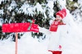 Child with letter to Santa at Christmas mail box in snow Royalty Free Stock Photo