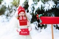 Child with letter to Santa at Christmas mail box in snow Royalty Free Stock Photo