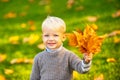 Happy child laughing and playing in autumn fall leaves on nature walk outdoors. Kids in autumn park on yellow leaf Royalty Free Stock Photo