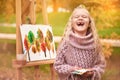 Happy child laughs. joyful little girl artist paints a picture in autumn in the park Royalty Free Stock Photo