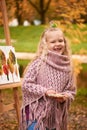 Happy child laughs. joyful little girl artist paints a picture in autumn in the park Royalty Free Stock Photo