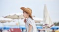 Happy child with a leather hat walking at the beach among the umbrellas..Close-up of a smiling child with cowboy hat, at the Royalty Free Stock Photo