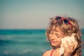 Happy child listen seashell on the beach Royalty Free Stock Photo