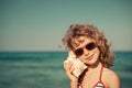 Happy child listen seashell on the beach Royalty Free Stock Photo