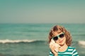 Happy child listen seashell on the beach Royalty Free Stock Photo