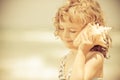 Happy child listen to seashell at the beach Royalty Free Stock Photo