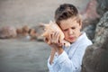 Happy child listen to seashell. vacations concept. Royalty Free Stock Photo