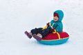 Happy child. little boy in winter ride on a sled from the mountain. Kid long and happy smiles