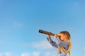 Happy child looking through vintage spyglass against blue sky Royalty Free Stock Photo