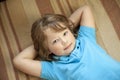 Happy Child Lying On Carpet Background. Boy Looking At Camera Royalty Free Stock Photo