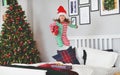 Happy child in pajamas with gifts jumping in bed on christmas m Royalty Free Stock Photo