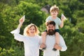 Happy child with parents playing with toy wings against summer sky background. Happy smiling boy on shoulder dad looking Royalty Free Stock Photo