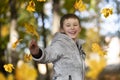 Happy child in the park outdoors, scatters leaves Royalty Free Stock Photo