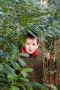 Happy child peeking through a gap in the tree