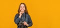 Happy child with photo camera. Child photographer yellow background, copy space