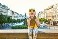 Happy child in pineapple sunglasses showing thumbs up in Prague