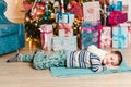 Baby lies on a plaid under a Christmas tree Royalty Free Stock Photo