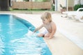 Happy child play near swimming pool with blue water at summer Royalty Free Stock Photo