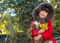 Happy child playing in autumn park. Kid gathering yellow fall foliage.