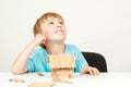 Happy child playing and building wooden home. Childhood dreams. Little boy builds his dream house. Happy life, house or mortgage