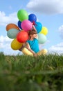 Happy child playing with colorful toy balloons outdoors Royalty Free Stock Photo