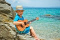 Happy child playing guitar by the sea greece on nature background Royalty Free Stock Photo