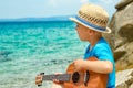 Happy child playing guitar by the sea greece on nature background Royalty Free Stock Photo