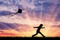 Happy child playing with kite on sunset