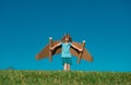 Happy child playing outside on green grass and blue sky. Kid pilot with toy jetpack. Kid boy play with toy plane Royalty Free Stock Photo