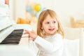 Happy child playing piano at modern class. Little girl at musical school. Education, skills concept. Preschool child learning to Royalty Free Stock Photo