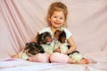 Happy child playing with puppies. Girl with the dogs. Children and animals.