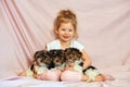 Happy child playing with puppies. Girl with the dogs. Children and animals.