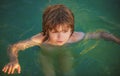 Happy child playing in the sea. Kid boy having fun on the beach. Summer vacation and healthy kids lifestyle concept. Royalty Free Stock Photo