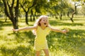 A happy child playing in a summer park. The girl is running, spinning, spinning and laughing. Entertainment during the Royalty Free Stock Photo