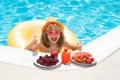 Happy child playing in swimming pool. Summer kids vacation. Summer fruit for children. Little kid boy relaxing in a pool Royalty Free Stock Photo