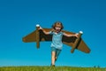 Happy child playing with toy jetpack. Kid pilot having fun on green grass outdoor. Success, kids innovation and leader Royalty Free Stock Photo