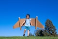 Happy child playing with toy jetpack. Kid pilot having fun on green grass outdoor. Success, kids innovation and leader Royalty Free Stock Photo