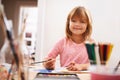 Happy child, portrait and drawing with color for creativity, learning or education at home. Young girl with paintbrush Royalty Free Stock Photo