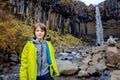 Happy child, posing in front of beautiful waterfall Svartifoss in Skaftafell national park i Royalty Free Stock Photo