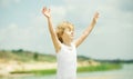 Happy child with raised arms standing near the sea. Royalty Free Stock Photo