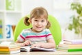 Happy child reading book at table in nursery Royalty Free Stock Photo