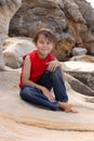 Happy child relaxes on rocks Royalty Free Stock Photo