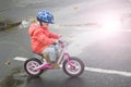 Happy child riding a bicycle in the fall. Cute little girl in safety helmet riding a bike outdoors. Little girl on a red bicycle. Royalty Free Stock Photo