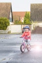 Happy child riding a bicycle in the fall. Cute little girl in safety helmet riding a bike outdoors. Little girl on a red bicycle. Royalty Free Stock Photo