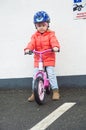 Happy child riding a bicycle in the fall. Cute little girl in safety helmet riding a bike outdoors. Little girl on a red bicycle. Royalty Free Stock Photo