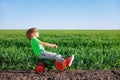 Happy child riding bike outdoor in spring green field Royalty Free Stock Photo