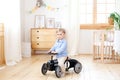 Happy child riding toy vintage car. Funny kid playing at home. Summer vacation and travel concept. Active little boy driving a car Royalty Free Stock Photo